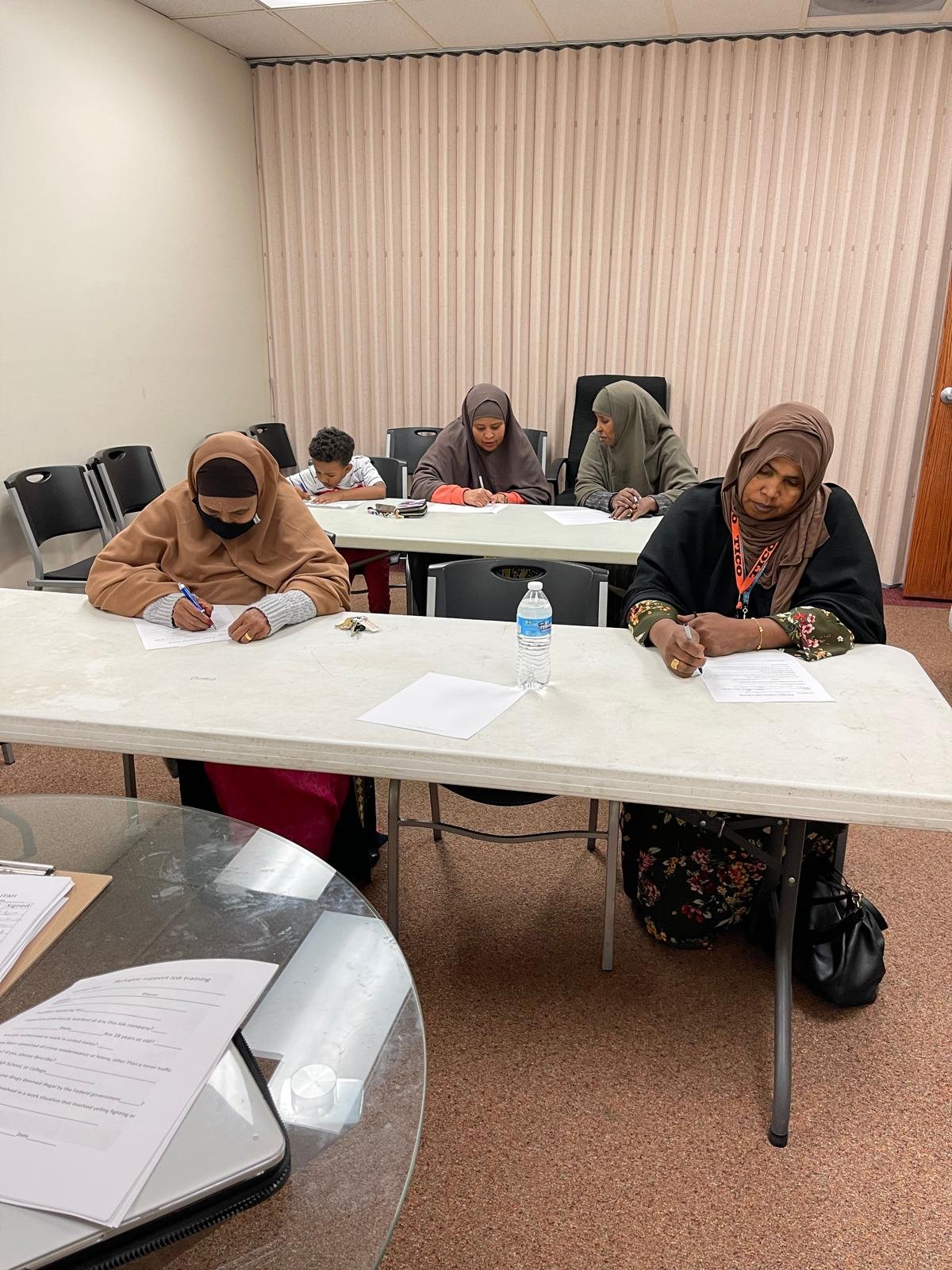 Community members completing written activities at the office